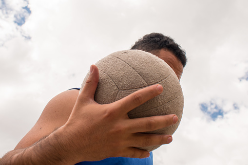 Low angle view of man playing with volleyball ball in sunny day