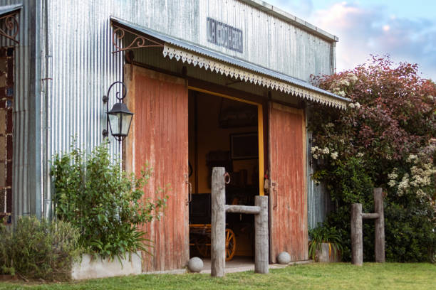 Old horse stable double door seen with a weathered look to the flaky white paint. Located on a rural English farm, long is disrepair.