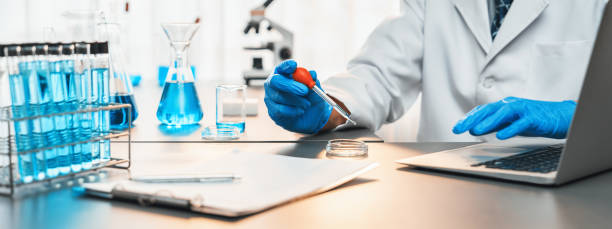 istock Scientist drop precise amount of liquid from pipette into test tube. Neoteric 2100604076