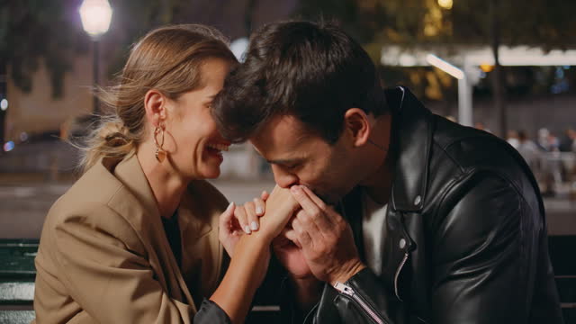 Man put engagement ring kissing girlfriend hand. Happy couple enjoying moment