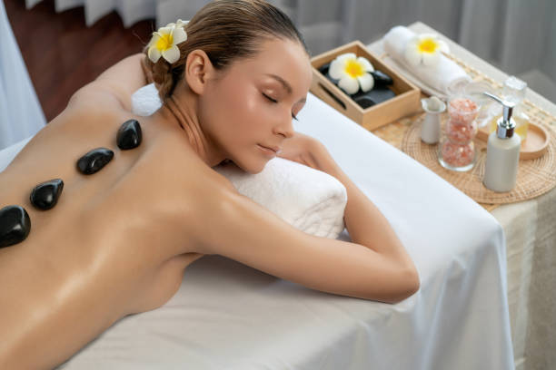 hot stone massage at spa salon in luxury resort. quiescent - lastone therapy massaging stone shiatsu - fotografias e filmes do acervo