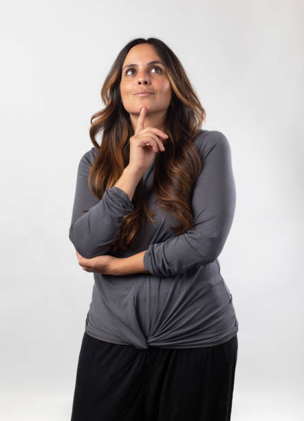 istock woman with hand on chin, thinking, on white background 2100677316