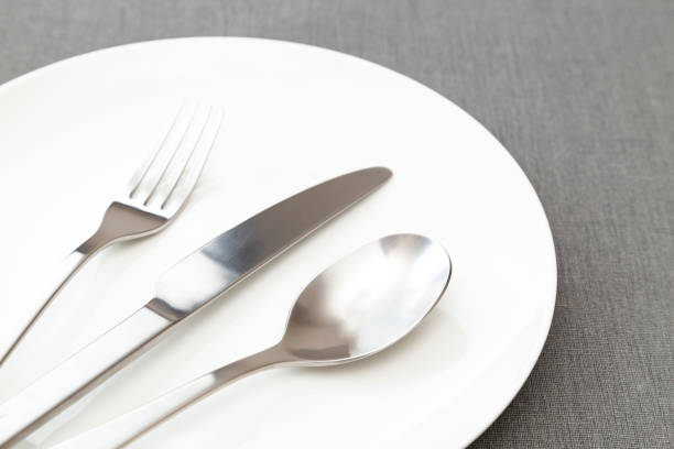 istock White plates and cutlery on the placemat. 2100726832