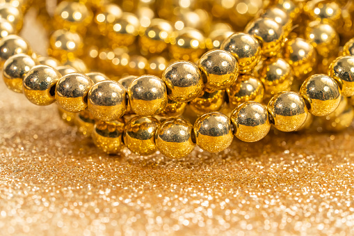 beautiful golden pearls against a golden glitter. Luxury jewelry background