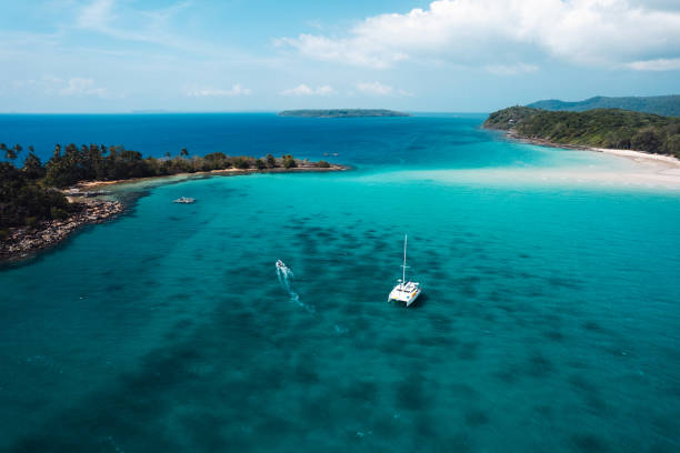 istock Boat floating on blue water at tropical island 2100756970