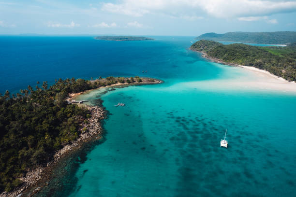 istock Boat floating on blue water at tropical island 2100757524