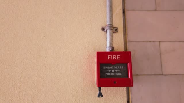 Red Fire Alarm Button on Apartment Building Wall