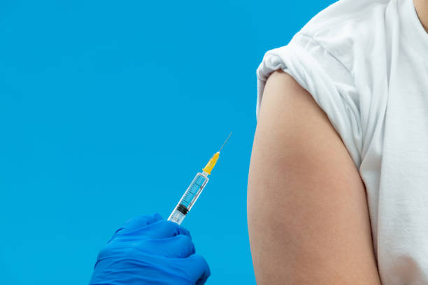 istock Doctor vaccinating for a boy on blue background 2100780396
