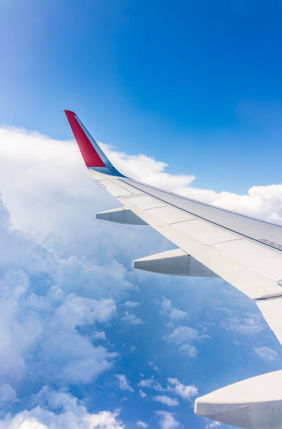 istock View from the airplane window at a beautiful cloudy sky and the airplane wing 2100815267