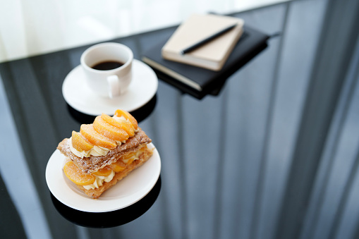 A peach strudel paired with a cup of rich black coffee makes for a perfect post-meal treat at a cozy cafe