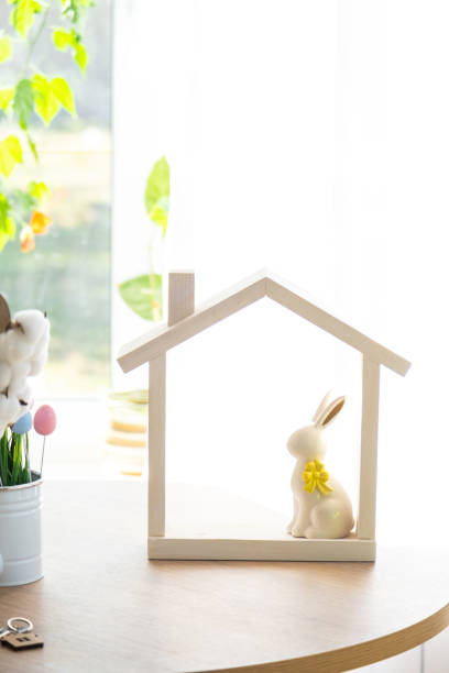 istock Tiny house of cozy home with Easter decor with rabbit and eggs on table of kitchen. Building, design, project, moving to new house, mortgage, insurance, rent and purchase real estate 2100877470
