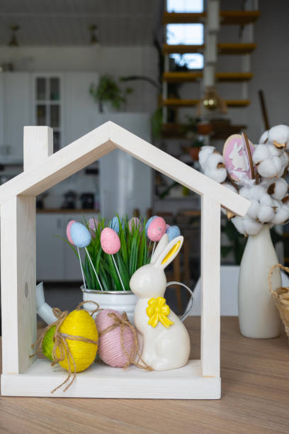 istock Tiny house of cozy home with Easter decor with rabbit and eggs on table of kitchen. Building, design, project, moving to new house, mortgage, insurance, rent and purchase real estate 2100877473