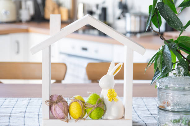 istock Tiny house of cozy home with Easter decor with rabbit and eggs on table of kitchen. Building, design, project, moving to new house, mortgage, insurance, rent and purchase real estate 2100877476