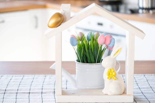 istock Tiny house of cozy home with Easter decor with rabbit and eggs on table of kitchen. Building, design, project, moving to new house, mortgage, insurance, rent and purchase real estate 2100877478