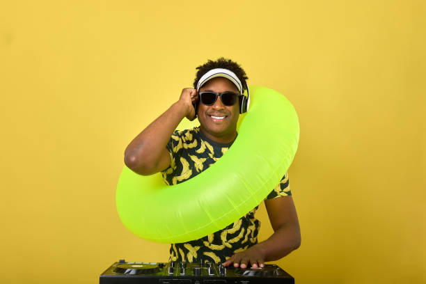 istock Fashionable dark-skinned guy DJ put on inflatable circle, plays popular music 2100879551