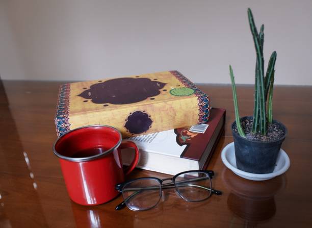 istock Books, glasses, cup of coffee and cactus plant on library table 2100929845
