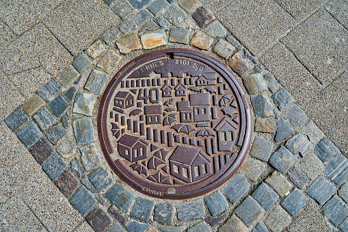 Alesund, Norway - 06 07 2022: heavy metal lid of a manhole in the city center of Alesund, a popular travel destination in Norway.