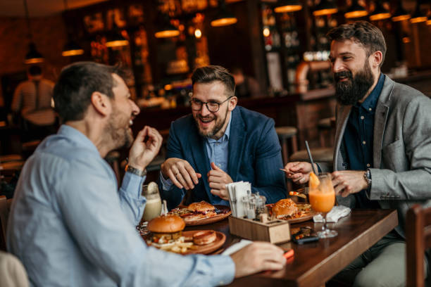 istock Three men in suits dining on burgers in a classy restaurant 2100981874
