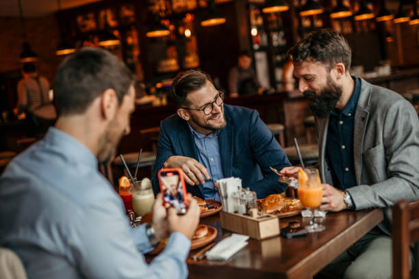 istock Three men in suits dining on burgers in a classy restaurant 2100982917