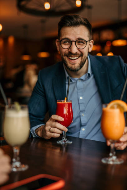 istock Corporate professionals enjoying a refreshing break with fruity cocktails at a bar table 2100987633
