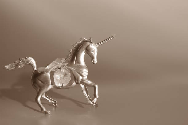 Creative close up on three plastic Horse Toy Figurine, two small with one adult white Horse with wings, and a child girl hands playing with them on the window.
