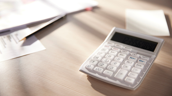 Desk with calculators for calculating, managing and\nanalyzing economic profits and losses.