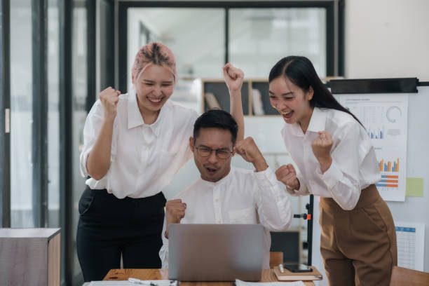 istock Enthusiastic Asian business team celebrating a successful project in office. Group achievement and teamwork concept. 2101012266