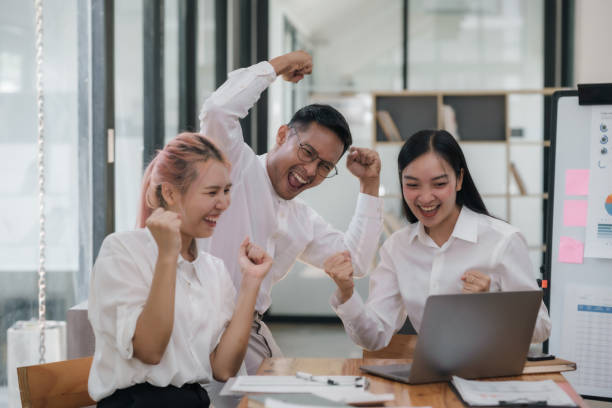istock Enthusiastic Asian business team celebrating a successful project in office. Group achievement and teamwork concept. 2101012268