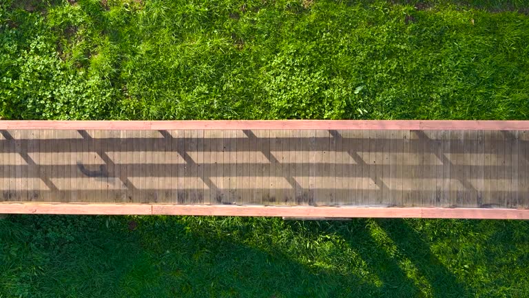 Overhead View Of A Man Walking On Wooden Bridge. - aerial shot