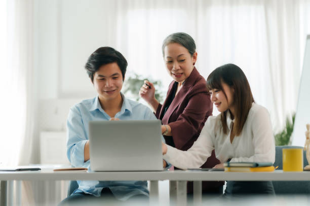 istock Asian boss or senior employee provide professional help and guidance to intern, practice corporate teamwork communication skill. 2101029164