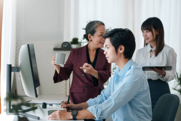 istock Asian boss or senior employee provide professional help and guidance to intern, practice corporate teamwork communication skill. 2101029174