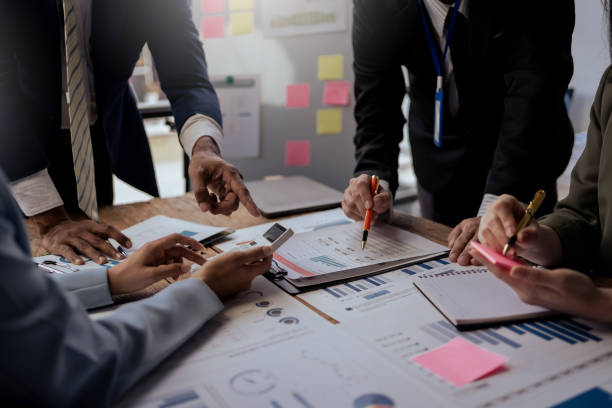 istock Teamwork process. Business people pointing at business document during discussion at meeting. Business people meeting explaining the financial graph data and marketing plan. 2101031808