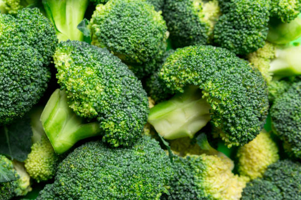 istock green fresh broccoli background close up on colored table. Vegetables for diet and healthy eating. Organic food 2101051480