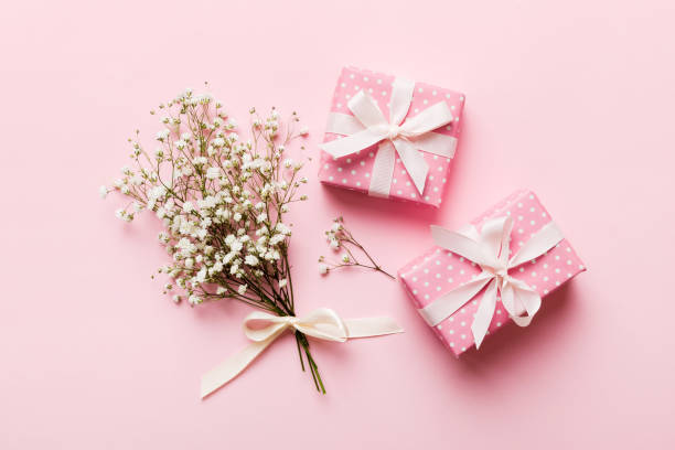 istock Gift or present box and flower gypsophila on light table top view. Greeting card. Flat lay style with copy space 2101052031