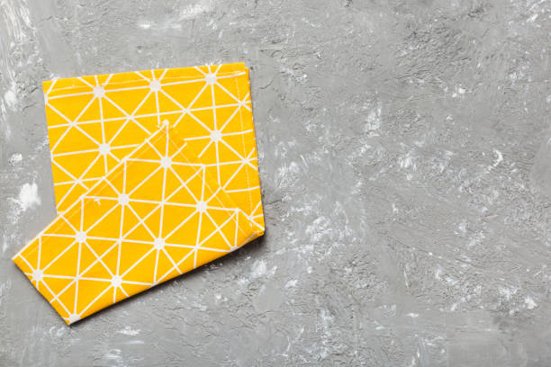 istock top view with yellow empty kitchen napkin isolated on table background. Folded cloth for mockup with copy space, Flat lay. Minimal style 2101052048