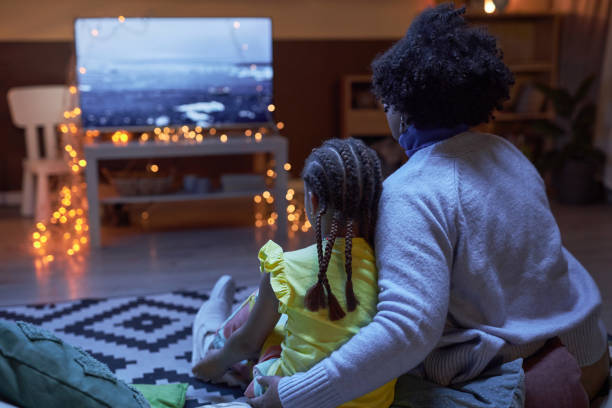 istock Black little girl with mom watching Tv 2101081071