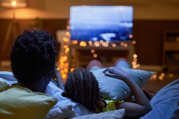 Family watching Tv together in dark