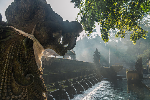 The holy spring water at the Tirta Empul temple near the city of Ubud, Bali, Indonesia, during a hot day on the tropical island.