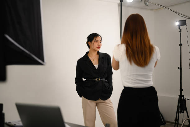 istock Elegant young female model posing for professional photographer in studio 2101111440