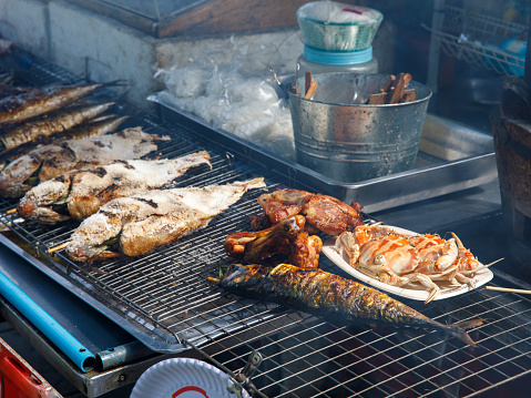 roast crab, pork and fish bbq, fish in salt on street food market tray grill