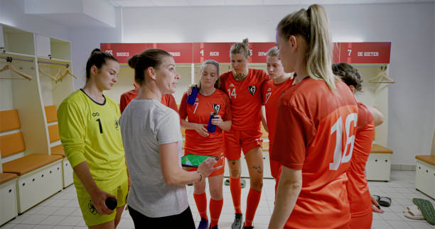 istock Coach explaining game strategy to football players 2101133132