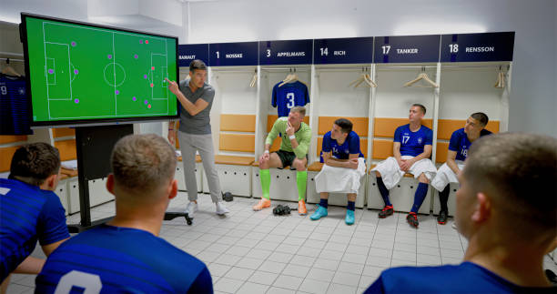 istock Coach explaining game strategy to football players 2101133656