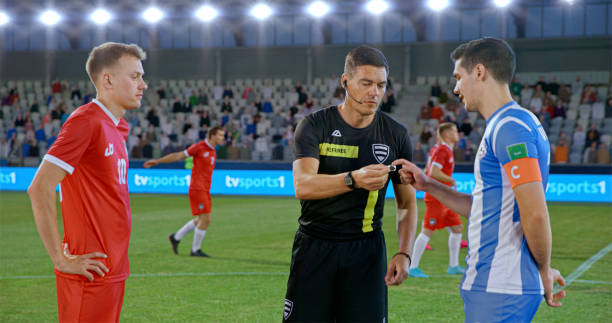 istock Referee showing toss coin to team captions 2101133662