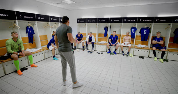 istock Coach explaining game strategy to football players 2101134213