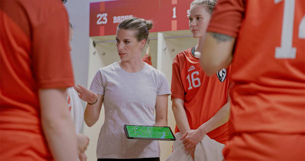 istock Coach explaining game strategy to football players 2101134744