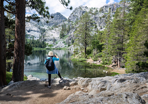 Woman taking photos using smartphone at Eagle Lake. Emerald Bay. South Lake Tahoe. California.