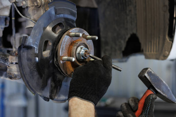 istock Auto mechanic installing car front brake caliper and brake pads. 2101175201