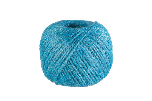 Yarn for crocheting. Top view, web banner with copy space. Concept hobby of handmade needlework from home. Several woolen multicolored balls of thread in wicker basket on a green crocheted background.