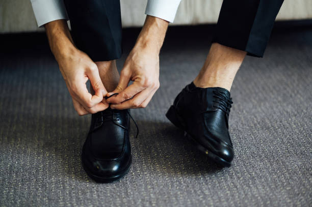 istock Man ties his black shoes. Close-up view 2101222025