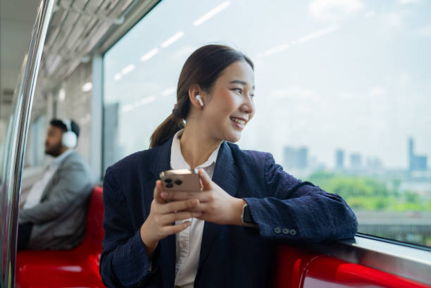 istock Asian woman using smartphone on skytrain 2101223504